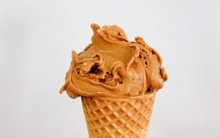 Ice Cream Overrun Image. Carmel colored ice cream in a waffle cone.