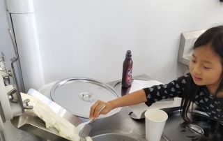 Choosing frozen custard equipment decisions. One decision is are customers going to serve themselves? This image shows an Asian girl spooning out frozen custard with a spoon.